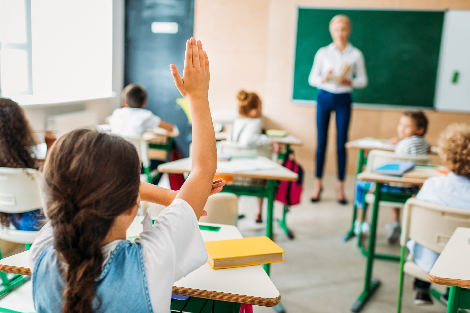 Girl raising her hand in an Elementary School classroom